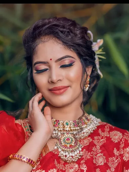 A close-up with eyes closed, focusing on the intricate details of the heavy necklace and the beautiful makeup.