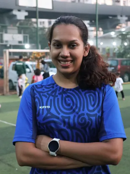 A portrait of one of our smiling coaches, happy to be on the field doing what she loves.