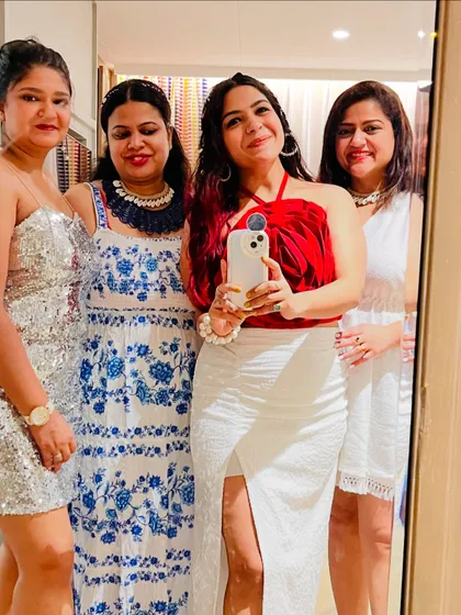 A mirror selfie with my girl gang in Goa. Everyone is dressed up for a night out, showcasing different party styles from a sequin dress to a chic white slit skirt.