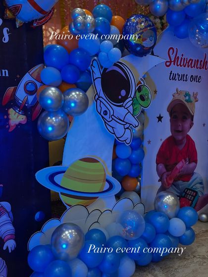 A detailed shot of the space theme decor, showing the mix of different balloon sizes, character cutouts, and planet props that add depth and interest to the main backdrop.