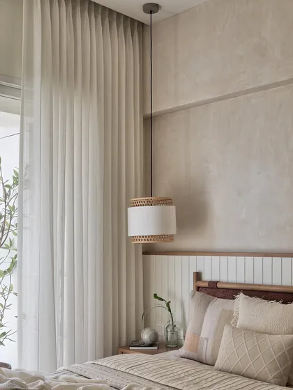 The oak-finished bed with a warm rust-brown boucle fabric stands gracefully against a wainscoted wall. The wall itself is a canvas of tranquility, painted in a captivating blend of ivory and beige textures.