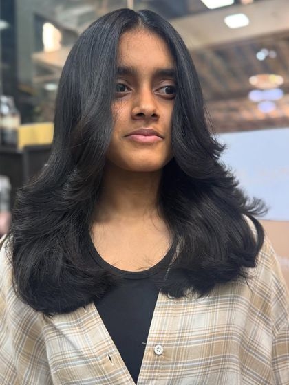 A classic portrait showing off a perfectly executed layered haircut. It's timeless, elegant, and full of volume.