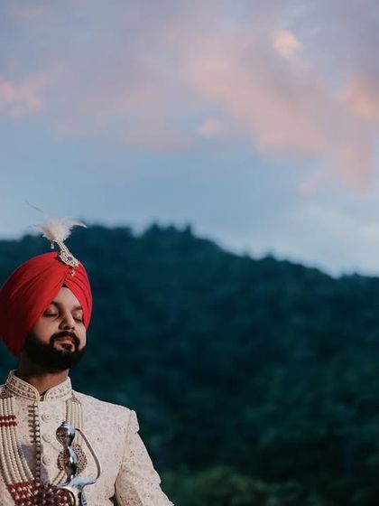 The groom in a moment of quiet reflection before the ceremony. The beautiful sky and natural landscape provide a stunning backdrop.