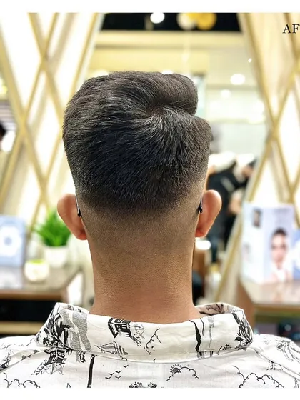 A perfect haircut is all in the details. This image displays the back view of a flawless skin fade, showcasing the clean lines and seamless blending our barbers achieve for a sharp, professional finish.