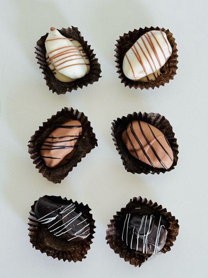 A minimalist shot of my assorted stuffed dates, coated in white, milk, and dark chocolate.