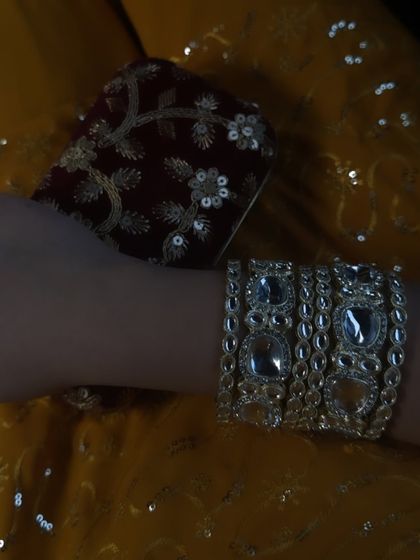 A detail shot focusing on my Kundan-style bracelet and the embroidered clutch, showing how accessories complete an ethnic look.