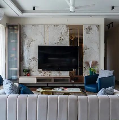 A close-up of a living room where we installed a floor-to-ceiling marble-patterned laminate TV wall with brass inlay details. We manage the precise cutting and joining required for such statement features.