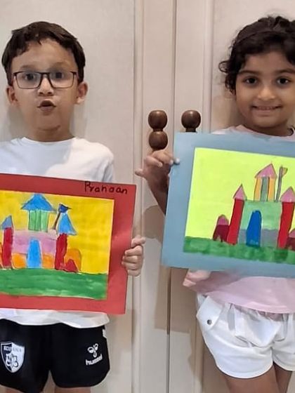 Two students showing off their finished castle drawings together. It's always fun to see the different creative paths taken from the same starting point.
