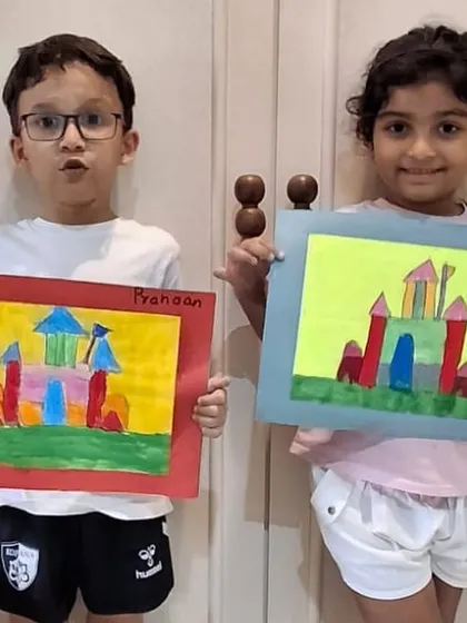Two students showing off their finished castle drawings together. It's always fun to see the different creative paths taken from the same starting point.