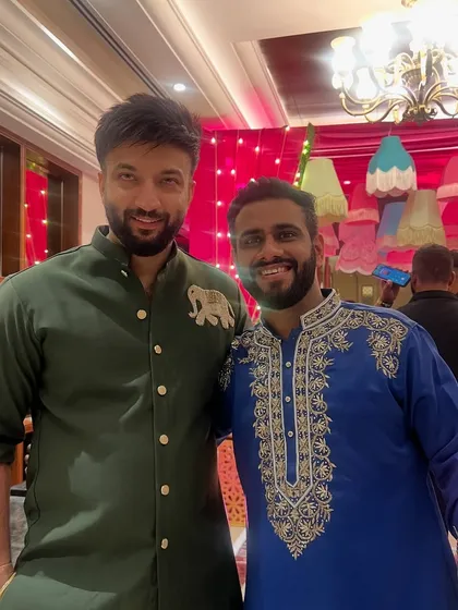 Our designer posing with a client in a vibrant blue kurta with heavy silver embroidery. This showcases the variety of colors and styles we offer.
