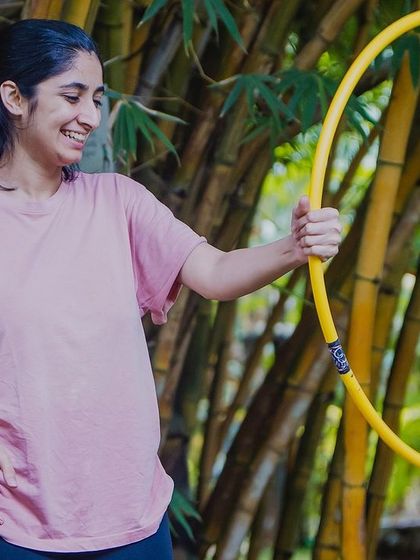 A candid shot of a student smiling as she gets the hang of her hoop. You don't need any prior experience, just a willingness to try something new.