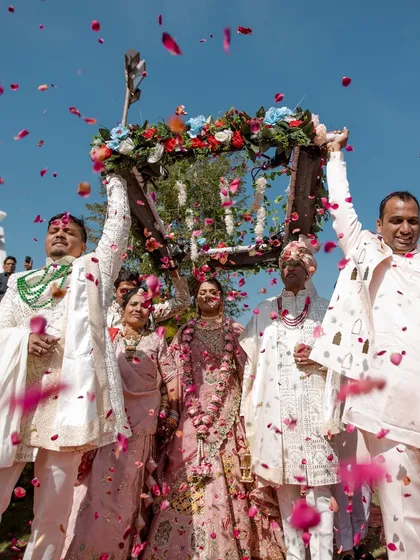 A joyous celebration as the bride is showered with flower petals by her family after the Varmala, a perfect candid moment of happiness.