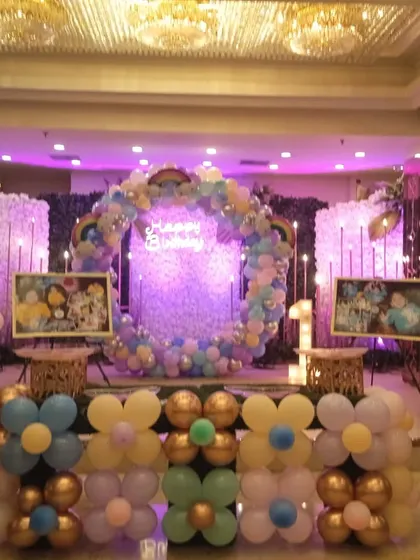 Another angle of the Boss Baby and Frozen party setup, highlighting the main stage with the balloon ring, neon sign, and character displays.