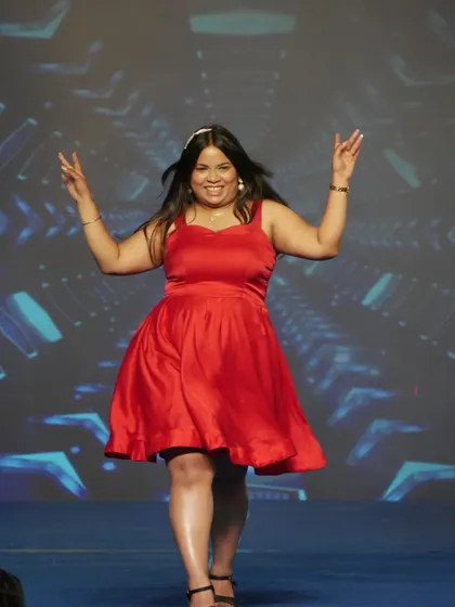 A student radiates joy and confidence on the runway during a cultural show. These experiences are invaluable for building self-assurance.
