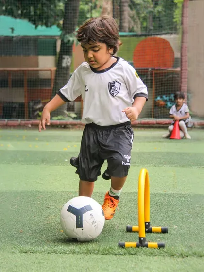 This player uses a mini hurdle to practice his dribbling, a creative way to build agility and ball-lifting skills.