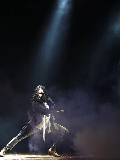 A dramatic solo performance, with smoke and spotlights creating a theatrical atmosphere.