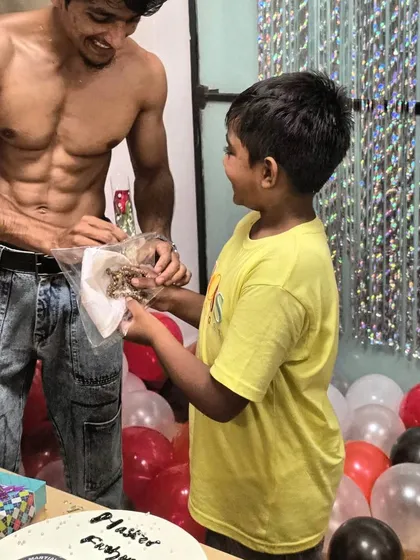 A candid moment from a celebration, but still showcasing the results of a consistent fitness lifestyle.