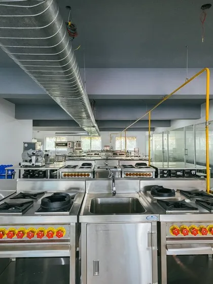Another perspective of the academy's kitchen, showcasing the individual workstations where students get hands-on training.
