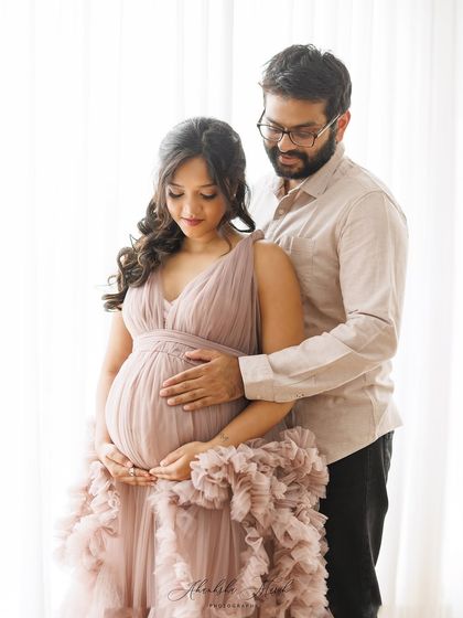 A soft, light-filled maternity portrait. The gentle embrace and pastel tones create a feeling of warmth and serenity in this beautiful couple's photo.