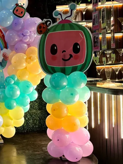 A Cocomelon TV character balloon pillar, adding another fun, themed element to the party space.