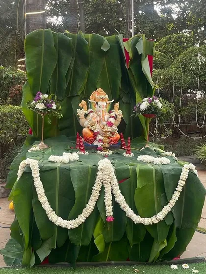A beautiful Ganesha idol decorated with banana leaves and traditional flower garlands. Placing a Ganesha at the entrance is a wonderful way to welcome guests and bless the occasion.