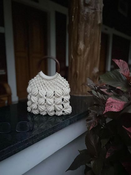 My macrame shell bag sitting pretty. The pattern is inspired by seashells, and the wooden handle gives it a very natural, earthy feel.