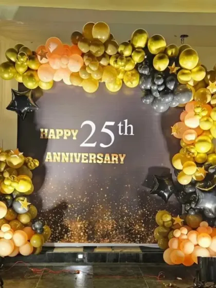 A close-up of the custom "Happy 25th Anniversary" backdrop, framed by a beautiful arch of gold, black, and peach balloons. This setup is perfect for celebrating a silver jubilee in style.