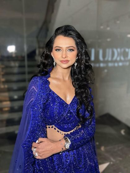 The sister of the bride in a stunning royal blue outfit. The makeup is glamorous and polished, perfect for a wedding reception.