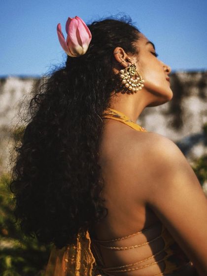 A beautiful back profile, capturing the sunlight on her hair and the intricate design of her halter top. This is a celebration of subtle, elegant details.