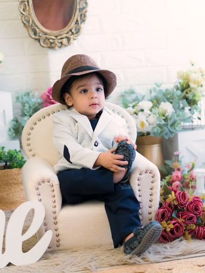 Posing like a pro for his first birthday. This little boy in his hat and suit looks absolutely charming and ready for his close-up.