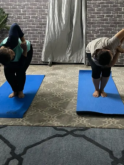 In this personal training session, I am guiding a student through a standing side bend and twist, focusing on balance and spinal mobility.