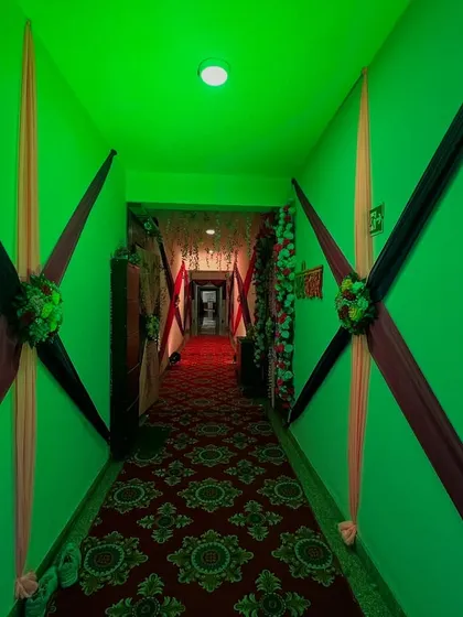 We also decorate walkways and corridors to ensure the entire venue is part of the celebration, like this hallway with green lighting and fabric drapes.