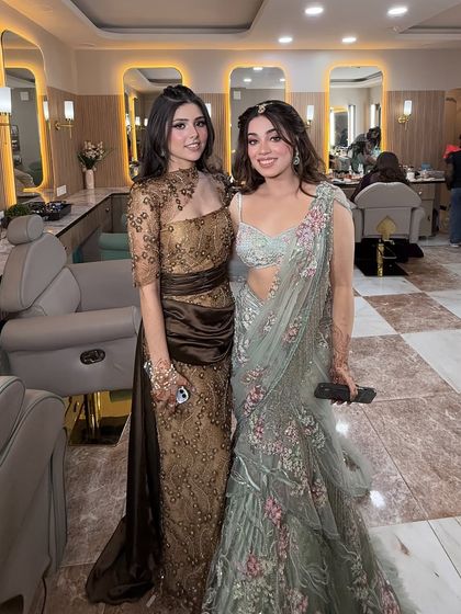 A full view of the sisters' stunning outfits and glamorous makeup. They are ready to make a grand entrance together.