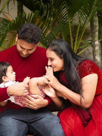 A playful and tender moment during an outdoor family shoot. The mother kissing her baby's feet is a classic gesture of love and affection.