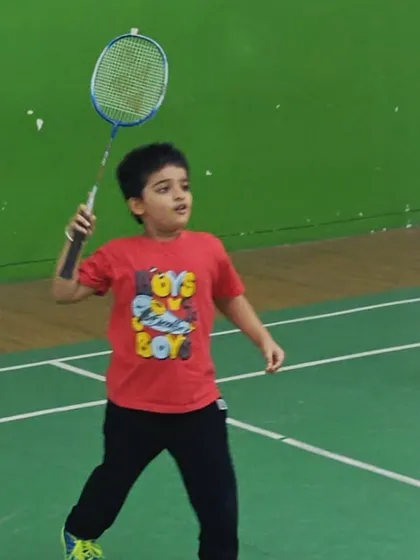 A young player focuses intently as he prepares to hit an overhead shot. My coaching emphasizes correct form and technique from the very beginning.