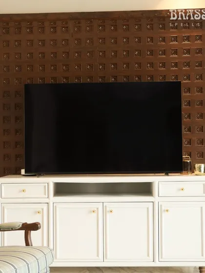 Our Sphere knobs on a white media console, set against a traditional carved wood panel. This shows how simple, classic hardware can bridge modern furniture and heritage decor.