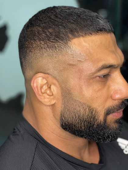 A high skin fade with a clean beard shape-up. This is a very strong and masculine look.