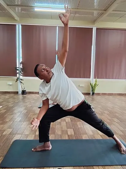 Two students hold a strong Parivrtta Parsvakonasana (Revolved Side Angle Pose). This standing twist builds strength, improves balance, and detoxifies the body.