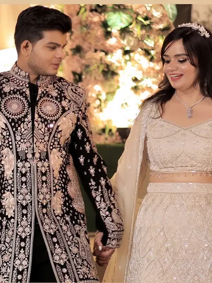 The couple walking hand-in-hand, a beautiful shot that captures their connection and her elegant look.