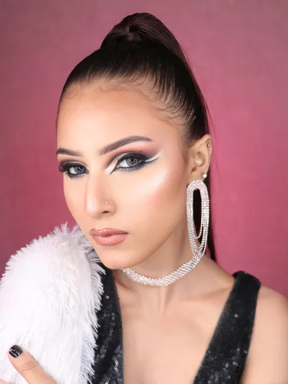 A powerful and fierce pose showcasing the dramatic white and black graphic eyeliner, a key feature of this high-fashion makeup look.