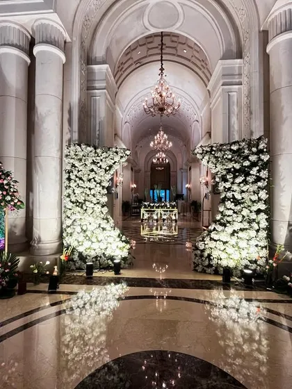 A grand entrance at The Leela Palace, New Delhi. I used massive floral structures shaped like the number '8' and personalized welcome signs to create a royal welcome for the guests.