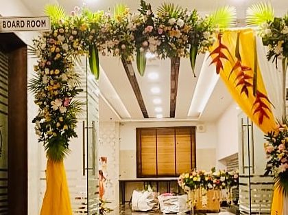 A closer look at the entrance arch for the half saree function, highlighting the mix of fresh flowers and painted leaves.