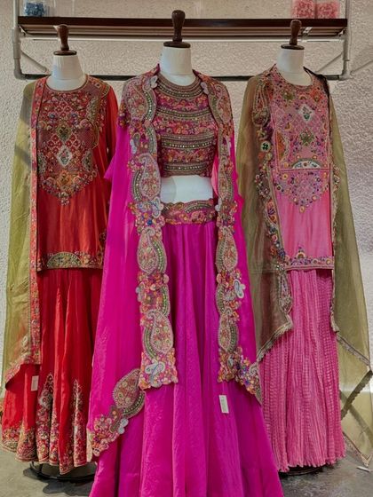 A full view of three exquisite outfits from Petticoat Lane, showcasing a vibrant mix of colors, heavy embroidery, and unique silhouettes.