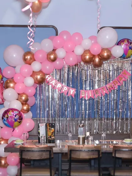 A closer look at the table setup for the princess party, showing the balloon arch and character foil balloons.