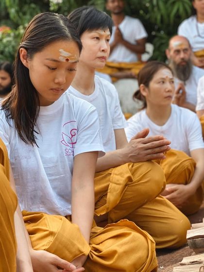 Students from diverse backgrounds sit together in meditation, each on their own journey, yet united in their quest for inner peace. The ashram is a melting pot of cultures with a shared spiritual goal.