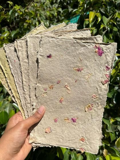 A stack of my finished handmade paper with rose petals. These sheets are perfect for writing notes, making tags for products, or crafting into a small notebook.