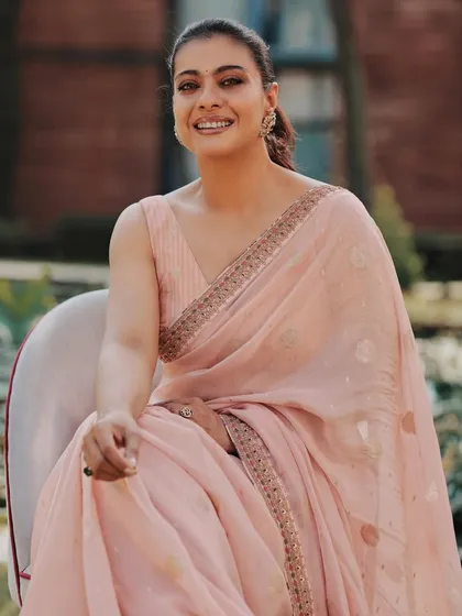 A happy, smiling portrait that captures the gentle and graceful nature of this pastel pink saree look.