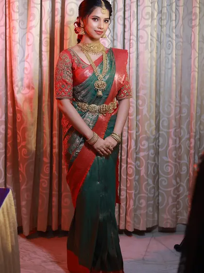 A full-length view of this gorgeous bride in her green and red Kanjivaram saree. The drape is tailored to be comfortable yet elegant for all the wedding rituals.