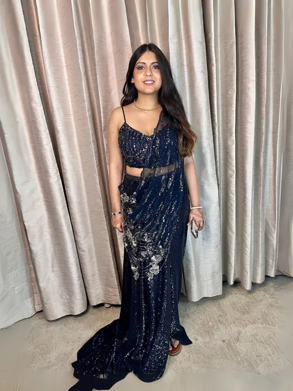 A full-length view of this redefined glamour. The makeup is understated yet elegant, letting the stunning outfit shine.
