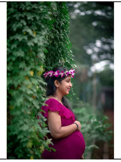 A lovely side-profile shot, framed by lush greenery, capturing a happy and candid moment.